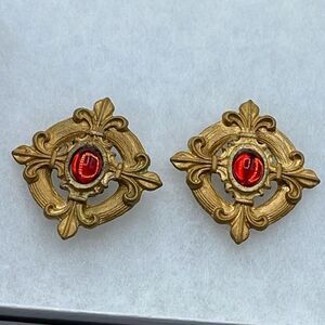 Vintage Fleur de lis gold tone metal red glass clip earrings.